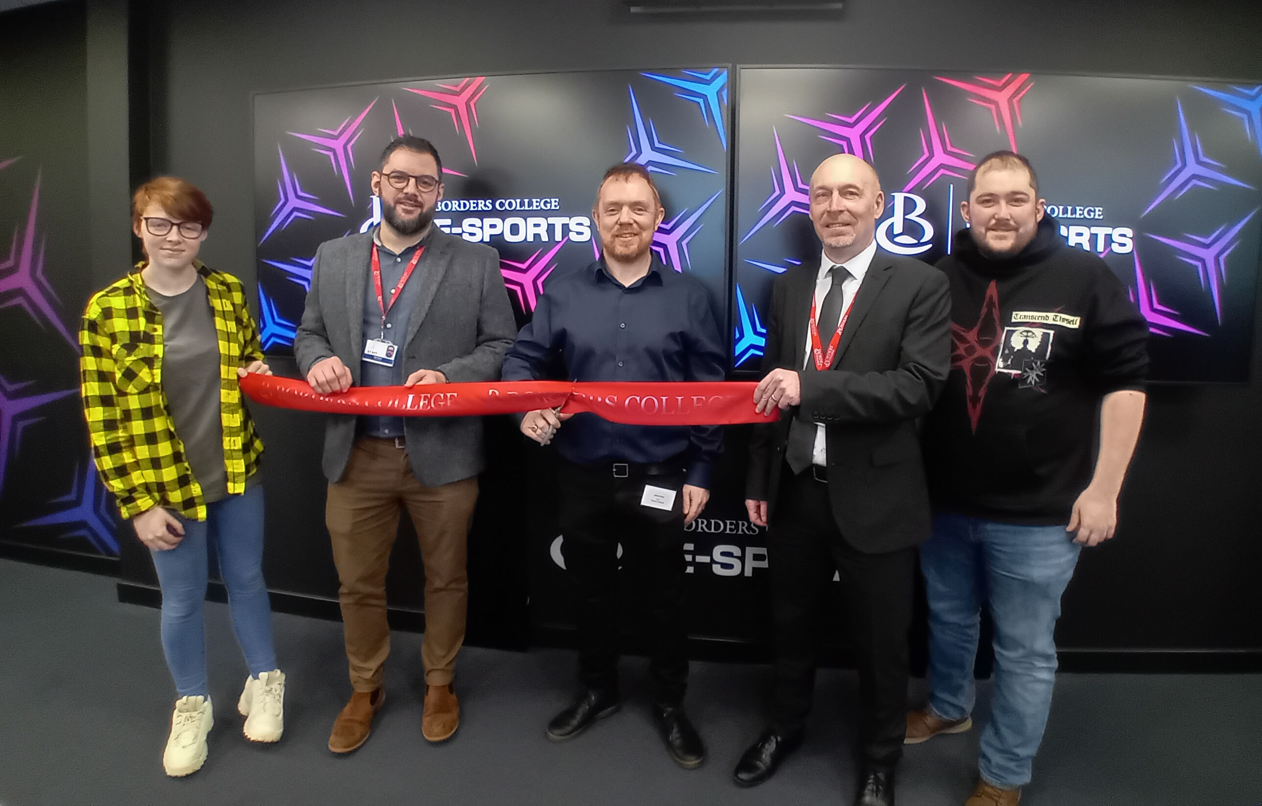 Group of people cutting a ribbon and officially opening the Esports Suite