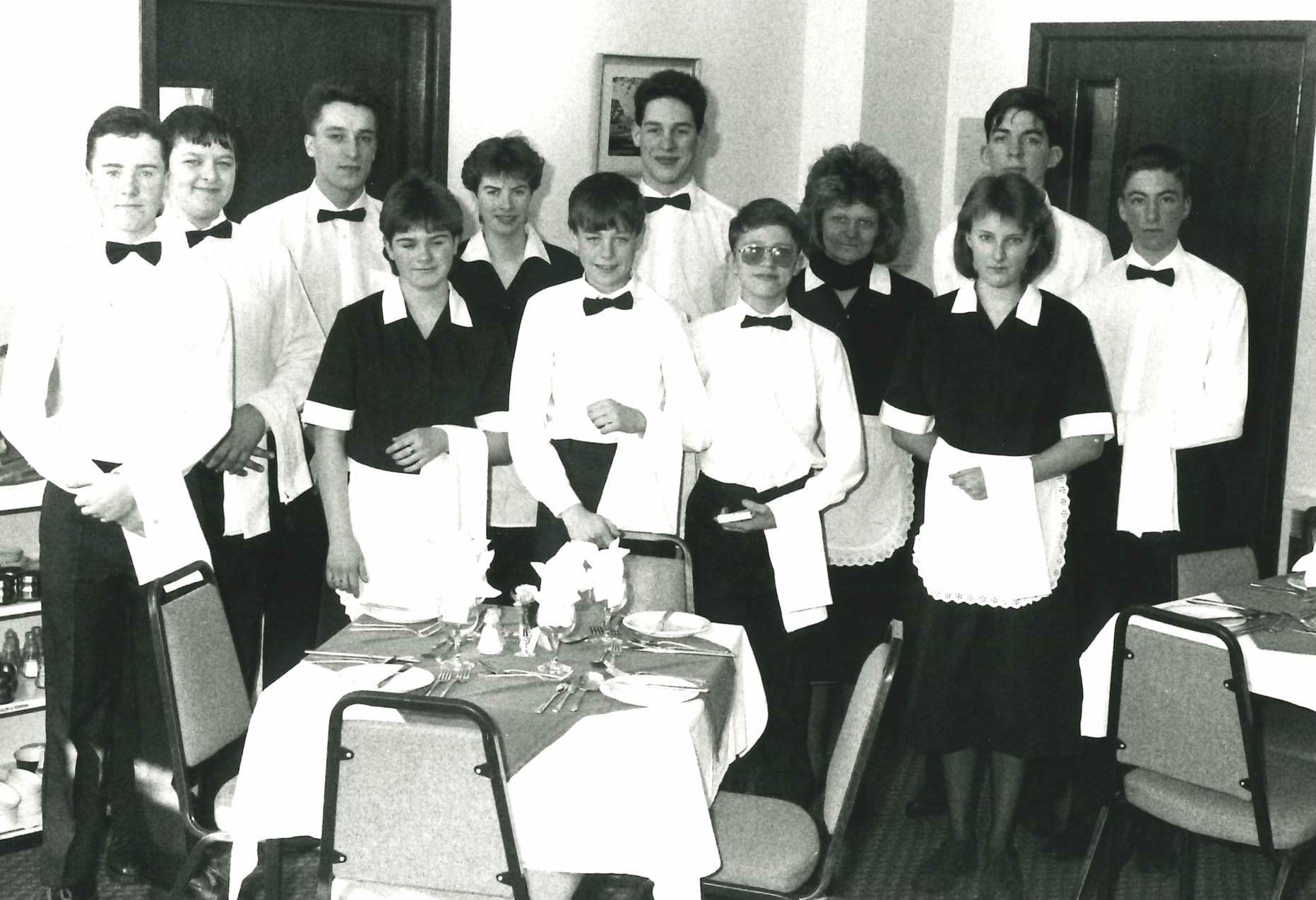 Old photo showing a group of catering students standing in the college restaurant