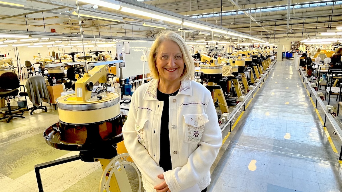 Photo of Jan Young standing in a knitwear factory