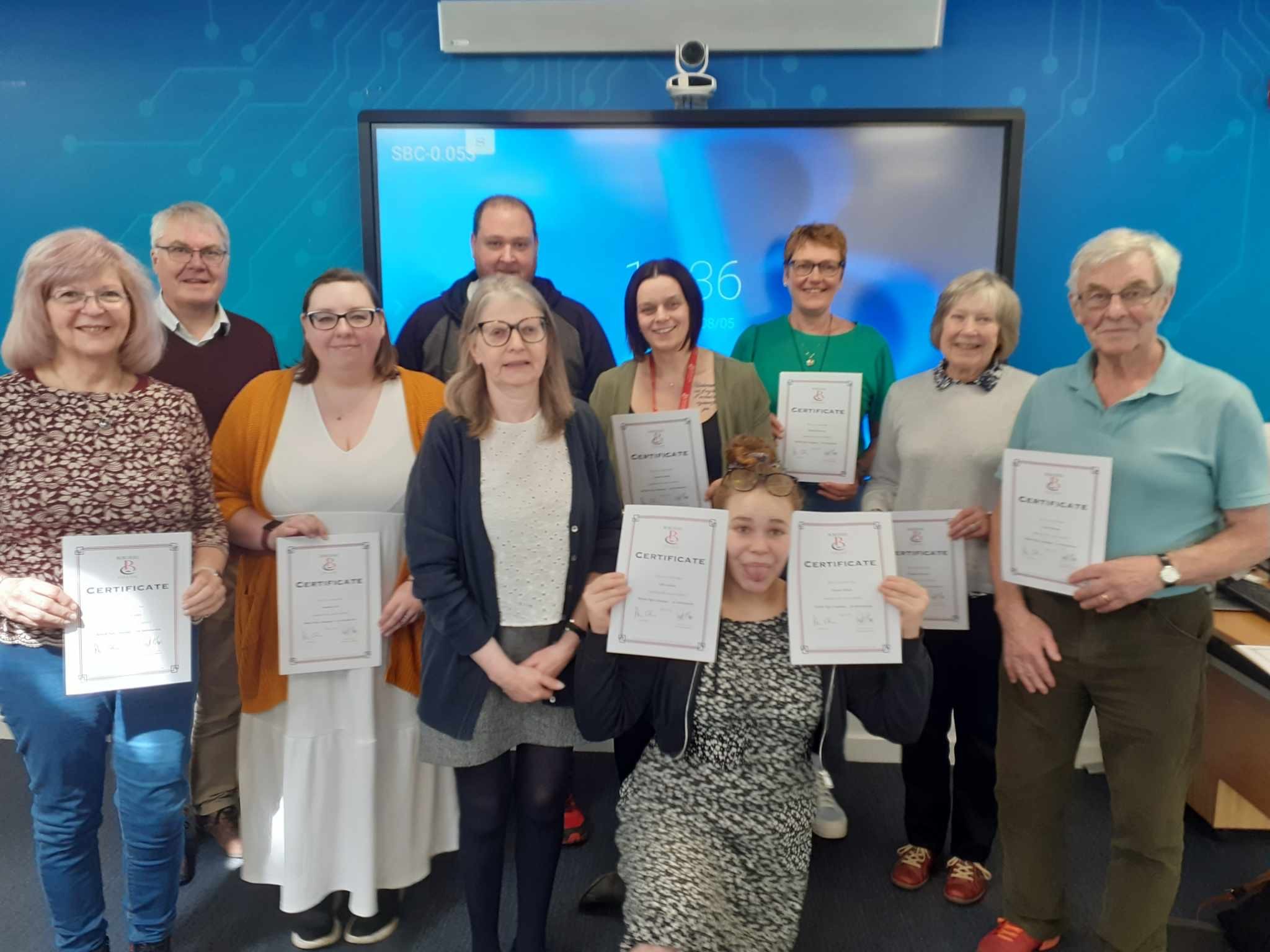 Group of students standing with certificates in their hands.