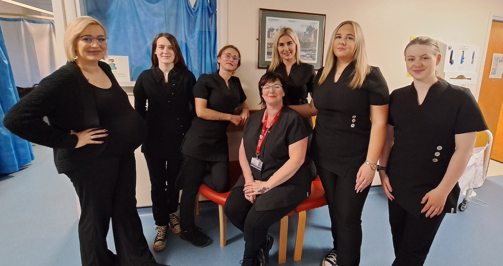 Group of hairdressing students standing in a hospital ward